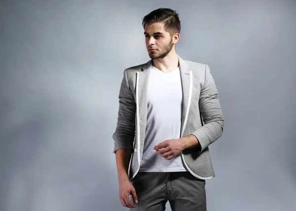 Young man on gray background — Stock Photo, Image