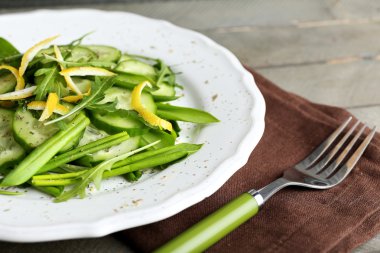 Yeşil salata tabağı, closeup salatalık, roka ve limon kabuğu ile