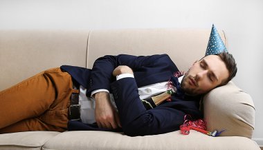 Genç adam eğlenceli kapattıktan sonra kanepede