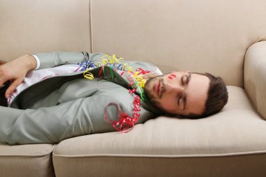 Genç adam eğlenceli kapattıktan sonra kanepede