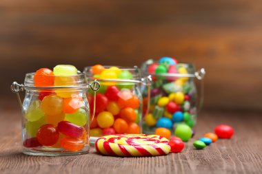 kavanoz masada ahşap arka plan üzerinde renkli şekerler