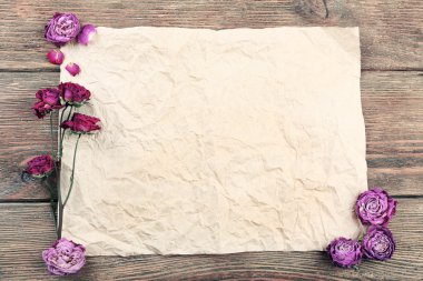 Ahşap masa, üstten görünüm üzerinde kağıt üzerine kurutulmuş güller