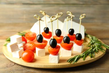 Peynirli kanepeler kiraz domates ve zeytin ahşap tepsi ile yakın çekim