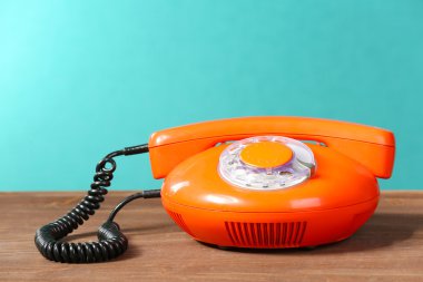 Retro red telephone on table on green background clipart