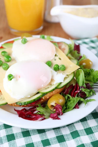 Sandwich mit pochierten Eiern, Käse und Gemüse auf dem Teller aus nächster Nähe — Stockfoto