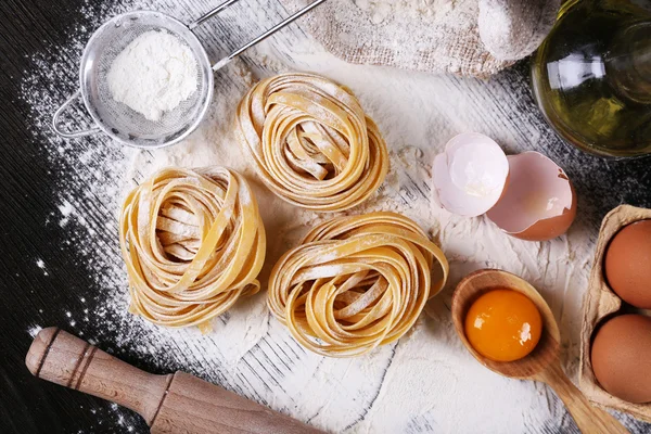 Pasta casera cruda e ingredientes para pasta sobre fondo de madera —  Fotos de Stock