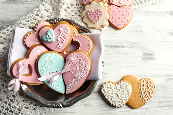 Cookies em forma de coração para dia dos namorados na placa, na cor de fundo de madeira — Fotografia de Stock