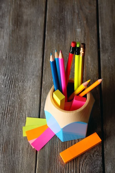 Colorful pencils in holder with sticky notes on wooden planks background — Stock Photo, Image