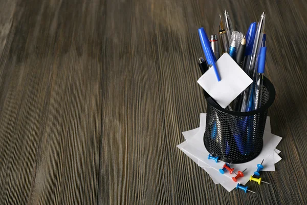 Bolígrafos en soporte de metal sobre fondo de mesa de madera — Foto de Stock