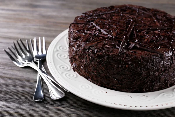 Pyszne ciasto czekoladowe w płytkę z widłami na drewnianym stole tło — Zdjęcie stockowe