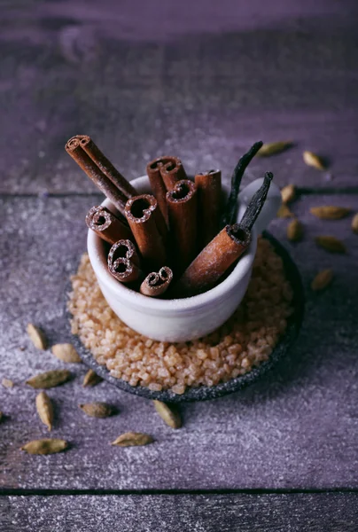 Tarçın ve vanilya sopa ahşap masa arka plan üzerinde şekerli — Stok fotoğraf