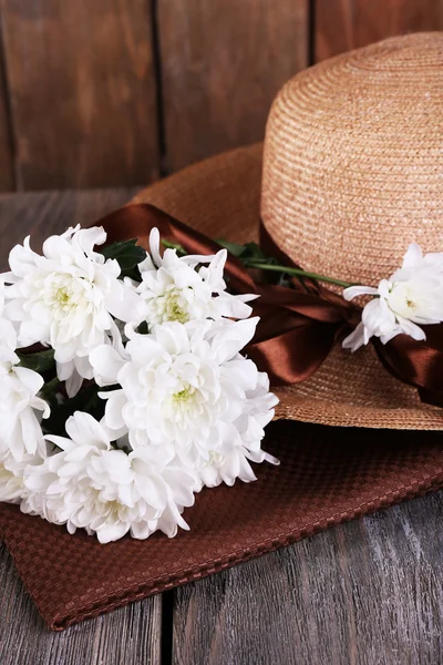 Hut mit Blumen auf Holzgrund — Stockfoto