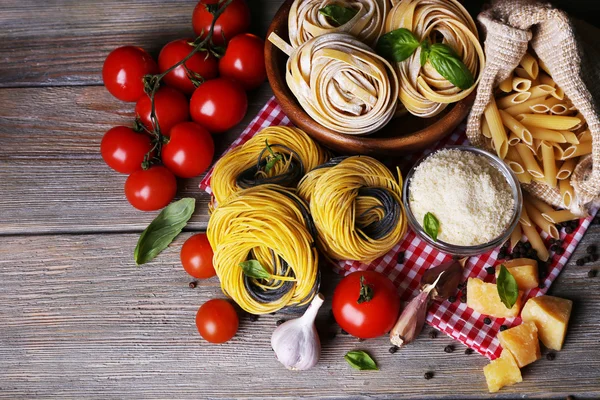 Massa com tomate cereja e outros ingredientes sobre fundo de mesa de madeira — Fotografia de Stock