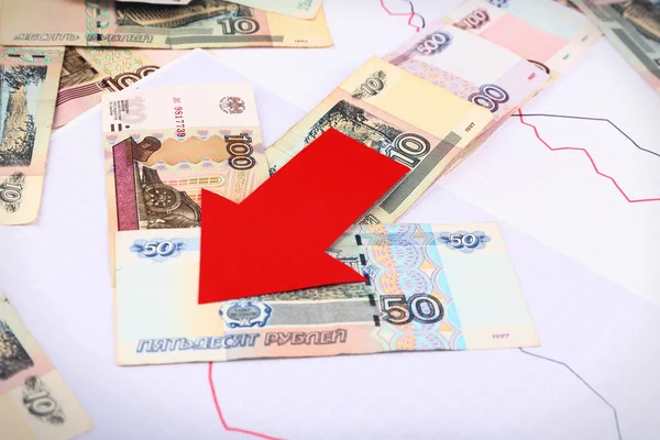 Geld en rode pijl op grafiek document close-up — Stockfoto