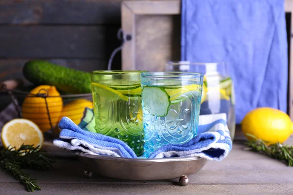 Čerstvá voda s citronem a okurky v sklo s ubrouskem na dřevěné pozadí — Stock fotografie