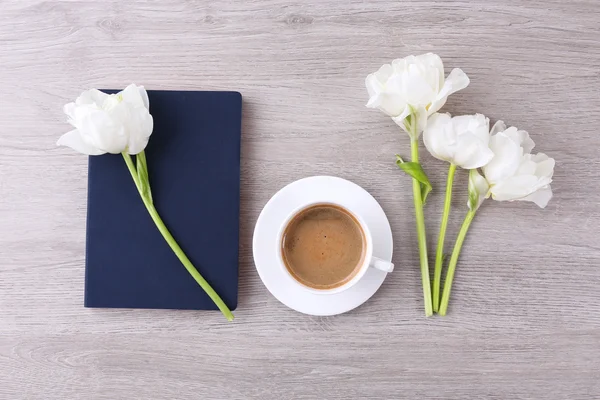 Hermosos tulipanes con diario y taza de café en la mesa de madera, vista superior —  Fotos de Stock