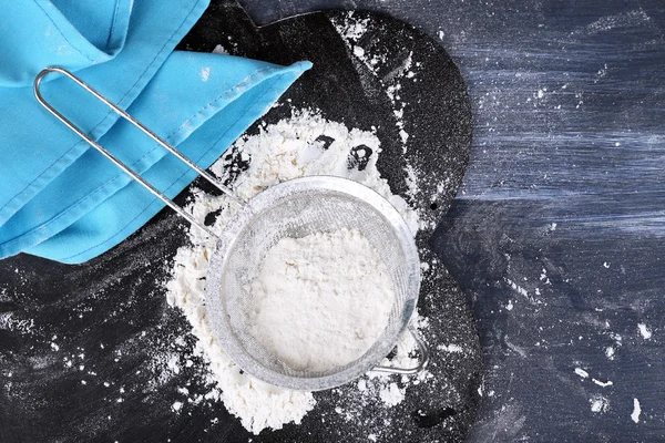 Sifting flour through sieve on wooden table, top view — Stock Photo, Image