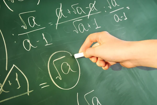 Teacher hand writing formulas on blackboard background — Stock Photo, Image