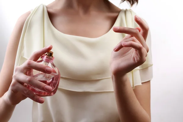 Mujer rociando perfume en su muñeca, primer plano — Foto de Stock