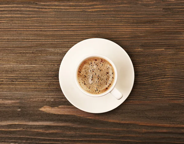 Secangkir kopi di atas meja kayu, pemandangan atas — Stok Foto