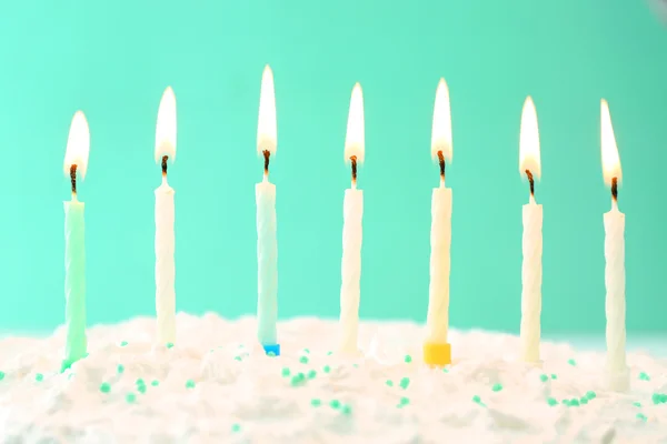 Tort urodzinowy ze świeczkami na tle koloru — Zdjęcie stockowe