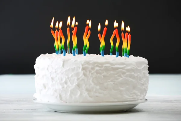 Bolo de aniversário com velas no fundo escuro — Fotografia de Stock