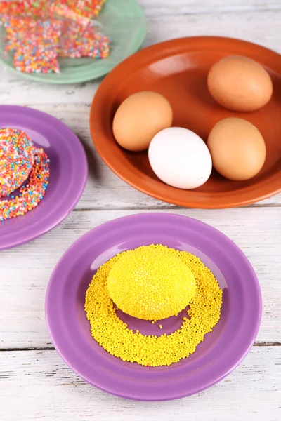 Decoración huevos de Pascua con cuentas de colores en la mesa de madera, primer plano —  Fotos de Stock