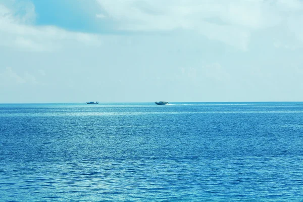 Widok piękny niebieski ocean wody z łodzie w kurorcie — Zdjęcie stockowe