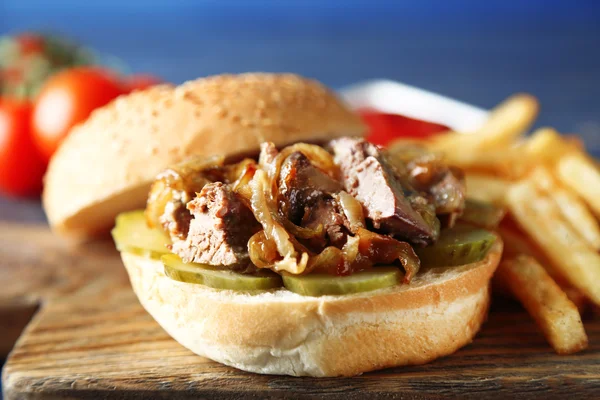 Hambúrguer saboroso e batatas fritas em fundo de mesa de madeira, close-up conceito de comida não saudável — Fotografia de Stock