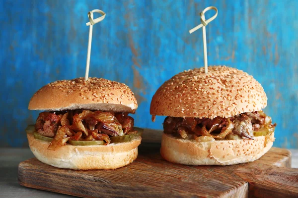 Gustoso panino sul tagliere, su sfondo di legno a colori. Concetto di cibo malsano — Foto Stock