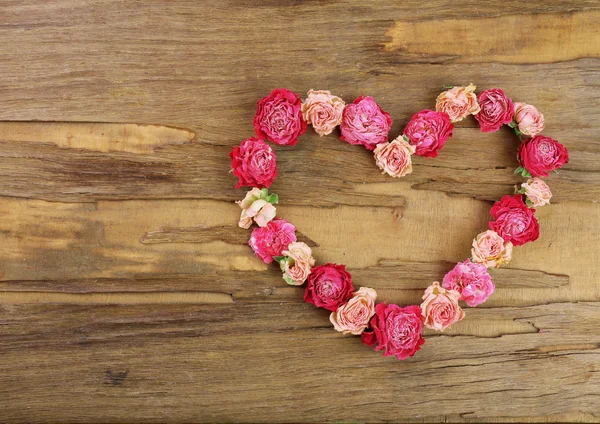 Heart of beautiful dry flowers on wooden background — Stock Photo, Image