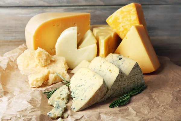 Various types of cheese with rosemary on table close up — Stock Photo, Image