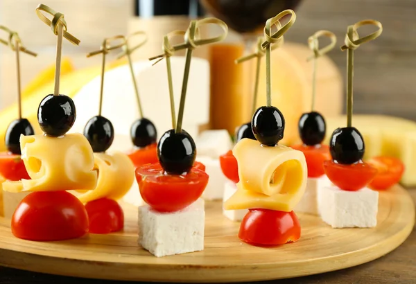 Cheese canapes with cherry tomatoes and olives on table close up — Stock Photo, Image