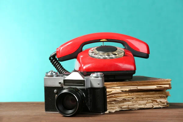 Cámara retro con libro viejo y teléfono en la mesa sobre fondo verde — Foto de Stock