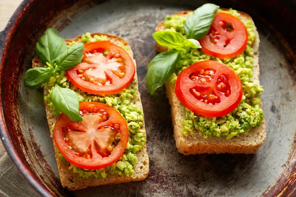 Vegansk smörgås med avokado och grönsaker på pannan, närbild — Stockfoto