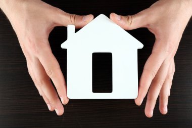 Ev ahşap arka plan üzerinde tutan eller