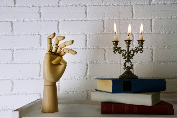 Bibliothèque avec livres et chandelier sur fond de mur de briques — Photo