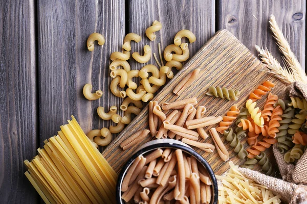 Verschiedene Arten von Pasta in Behältern auf Holzgrund — Stockfoto