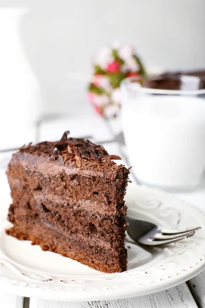 Sliced tasty chocolate cake in plate on wooden table, closeup — Stock Photo, Image