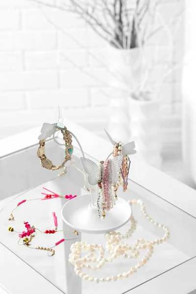 Decorative stand with jewelry and bijouterie on table in room — Stock Photo, Image