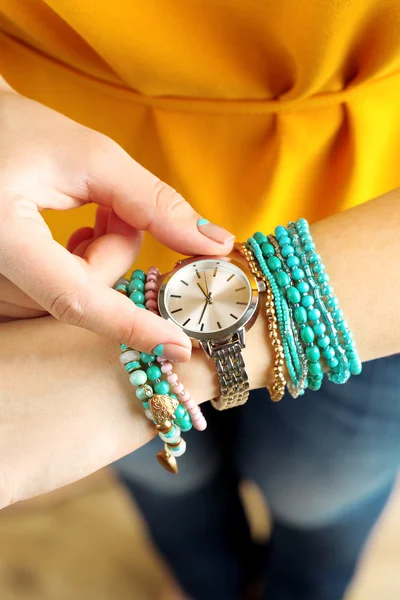 Stylish bracelets and clock on female hand top view — Stock Photo, Image