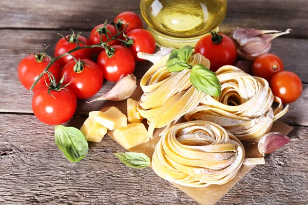 Pasta con pomodorini e altri ingredienti su fondo tavola in legno — Foto Stock