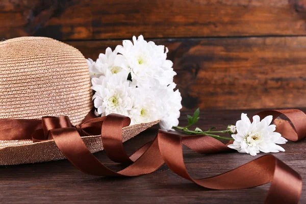 Hut mit Blumen auf Holzgrund — Stockfoto