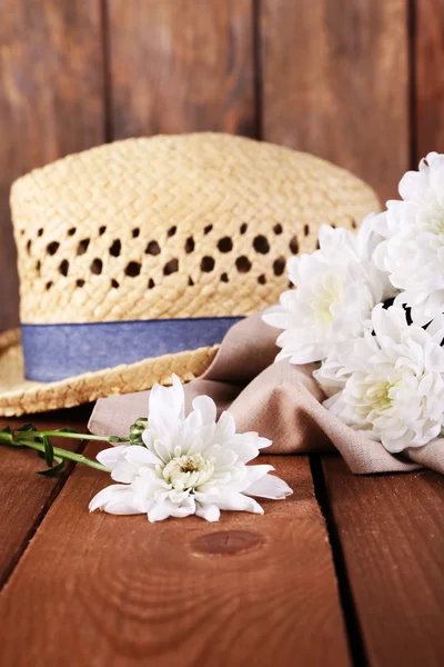 Hut mit Blumen auf Holzgrund — Stockfoto