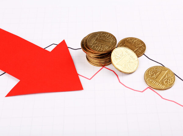 Coins and red arrow on graph document close up