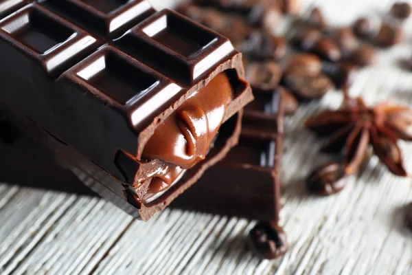 Chocolate relleno con granos de café en la mesa de madera, primer plano — Foto de Stock