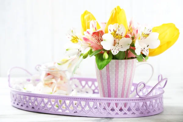 Beautiful flowers in cup, on wooden background — Stock Photo, Image