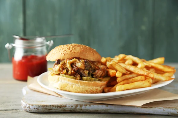 Smakelijke sandwiches en Franse frietjes op plaat, op houten achtergrond. ongezond voedsel concept — Stockfoto