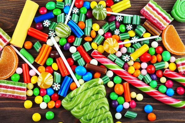 Bunte Bonbons auf hölzernem Hintergrund — Stockfoto