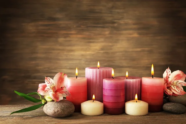 Velas com flores no fundo de madeira — Fotografia de Stock